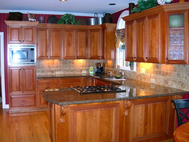 Exemple d'une cuisine craftsman en L et bois brun avec un placard à porte persienne, un plan de travail en granite, une crédence beige et une crédence en céramique.