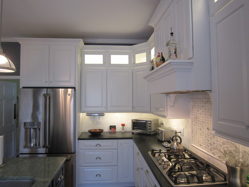 Inredning av ett klassiskt stort kök och matrum, med luckor med upphöjd panel, vita skåp, stänkskydd i stenkakel, rostfria vitvaror och vitt stänkskydd