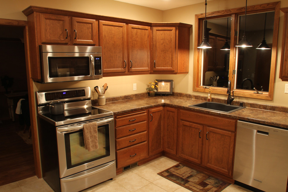 ミネアポリスにあるコンテンポラリースタイルのおしゃれなキッチン (シングルシンク、レイズドパネル扉のキャビネット、中間色木目調キャビネット、ラミネートカウンター) の写真