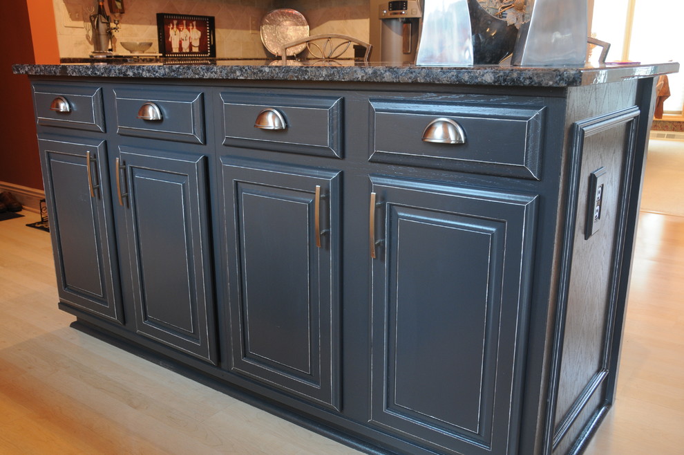 Diseño de cocina tradicional grande con armarios con paneles con relieve, puertas de armario con efecto envejecido, encimera de granito y suelo de madera clara