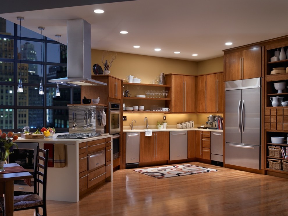 Imagen de cocinas en U contemporáneo abierto con electrodomésticos de acero inoxidable, armarios con paneles lisos y puertas de armario de madera oscura