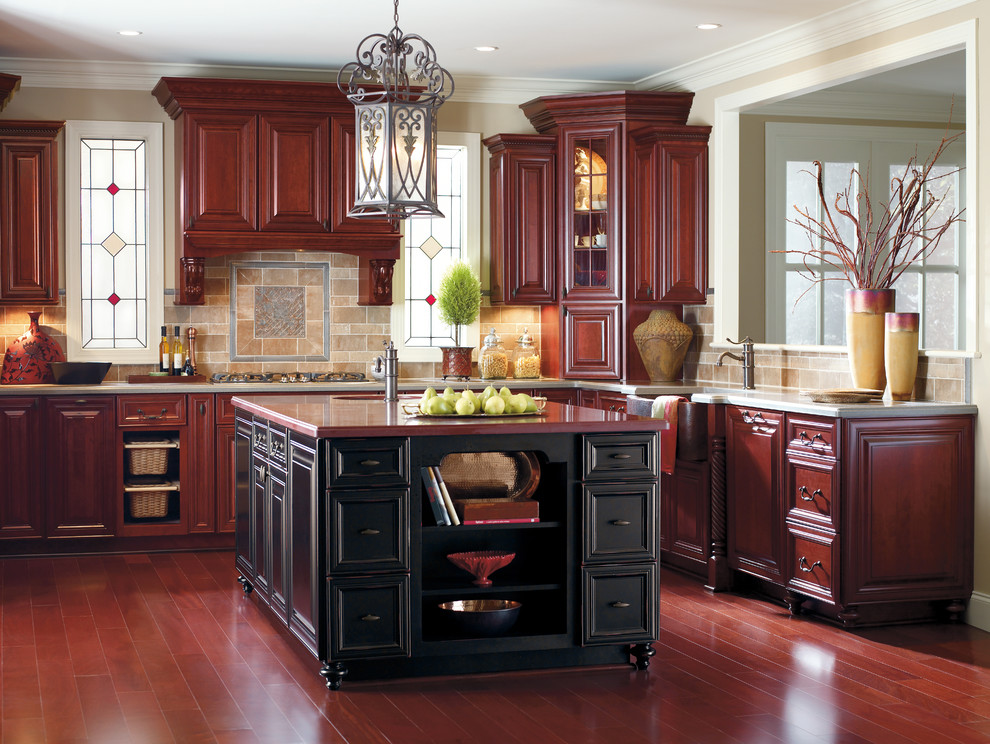 Cette image montre une grande cuisine américaine traditionnelle en L avec des portes de placard rouges, îlot, une crédence marron, une crédence en céramique et un placard avec porte à panneau surélevé.