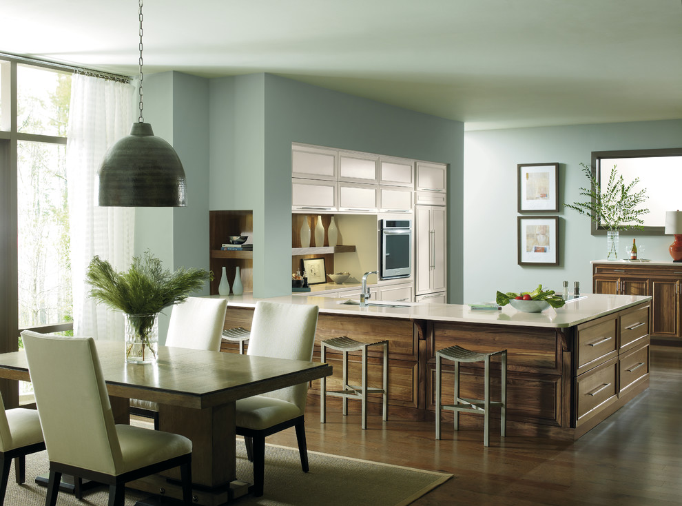 Idée de décoration pour une petite cuisine américaine minimaliste en L et bois brun avec 2 îlots et un placard avec porte à panneau encastré.