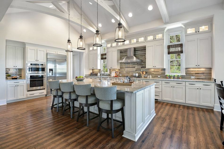 Inredning av ett klassiskt stort grå grått kök, med en rustik diskho, luckor med infälld panel, vita skåp, granitbänkskiva, flerfärgad stänkskydd, stänkskydd i stickkakel, rostfria vitvaror, mörkt trägolv, en köksö och brunt golv