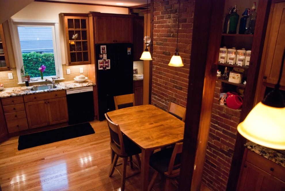 ニューヨークにある中くらいなトラディショナルスタイルのおしゃれなキッチン (アンダーカウンターシンク、落し込みパネル扉のキャビネット、中間色木目調キャビネット、御影石カウンター、ベージュキッチンパネル、ガラスタイルのキッチンパネル、黒い調理設備、淡色無垢フローリング、アイランドなし、茶色い床、マルチカラーのキッチンカウンター) の写真