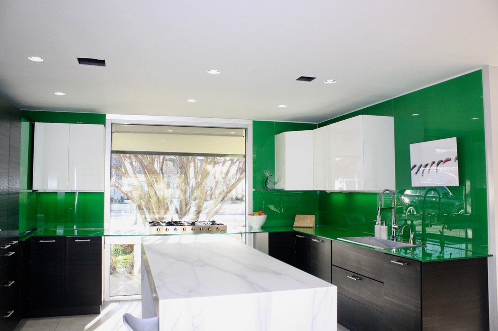 Exemple d'une cuisine moderne avec un plan de travail en verre, une crédence verte, une crédence en feuille de verre et un plan de travail vert.