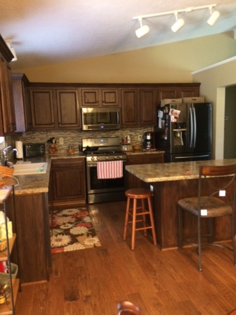 Inspiration for a mid-sized timeless l-shaped dark wood floor and brown floor enclosed kitchen remodel in Cincinnati with a double-bowl sink, raised-panel cabinets, dark wood cabinets, granite countertops, multicolored backsplash, matchstick tile backsplash, stainless steel appliances and an island