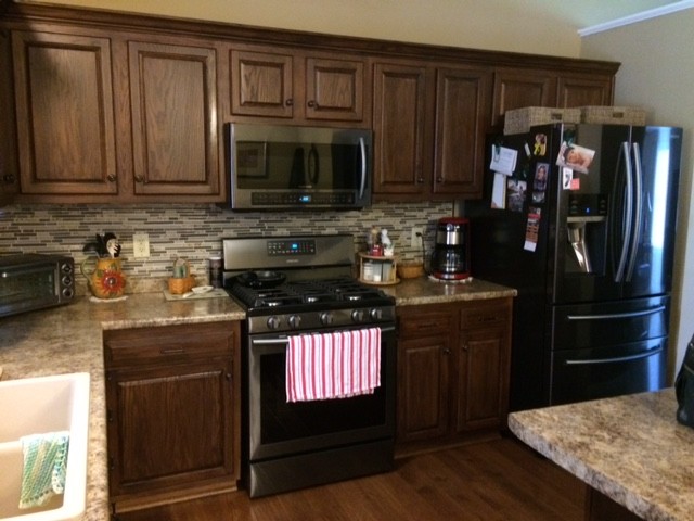 Inspiration for a mid-sized timeless l-shaped dark wood floor and brown floor enclosed kitchen remodel in Cincinnati with a double-bowl sink, raised-panel cabinets, dark wood cabinets, granite countertops, multicolored backsplash, matchstick tile backsplash, stainless steel appliances and an island