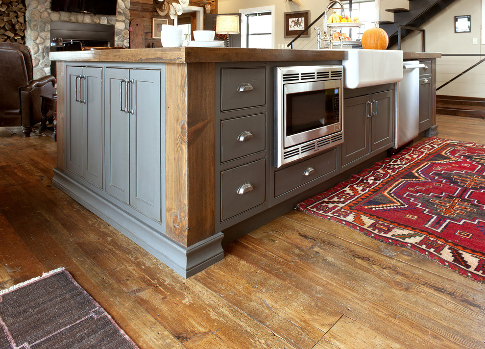 Inspiration för ett mellanstort rustikt kök, med en rustik diskho, luckor med profilerade fronter, grå skåp, träbänkskiva, rostfria vitvaror, mellanmörkt trägolv, en köksö och brunt golv