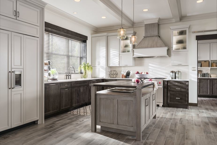 Inspiration for a large rustic l-shaped dark wood floor kitchen pantry remodel in Houston with an undermount sink, recessed-panel cabinets, white cabinets, solid surface countertops, white backsplash, stainless steel appliances and an island