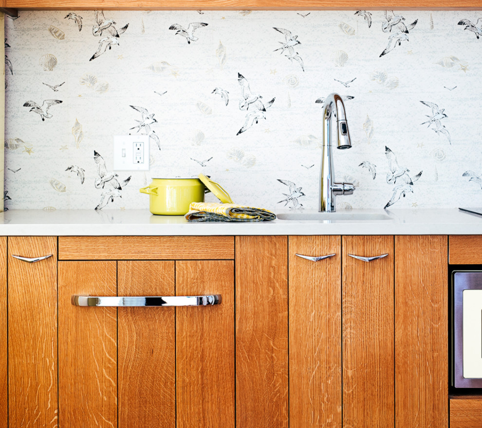 Esempio di una piccola cucina lineare stile marinaro con lavello sottopiano, ante lisce, ante in legno scuro, elettrodomestici colorati, pavimento in legno massello medio e top bianco