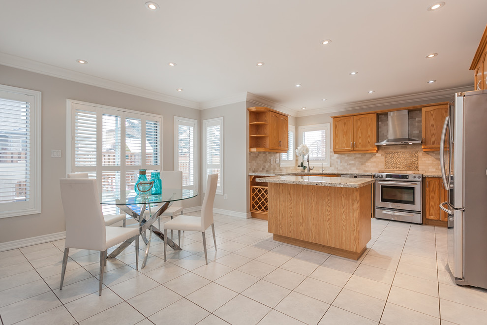Large classic l-shaped open plan kitchen in Toronto with a double-bowl sink, recessed-panel cabinets, brown cabinets, granite worktops, beige splashback, mosaic tiled splashback, stainless steel appliances, porcelain flooring and an island.