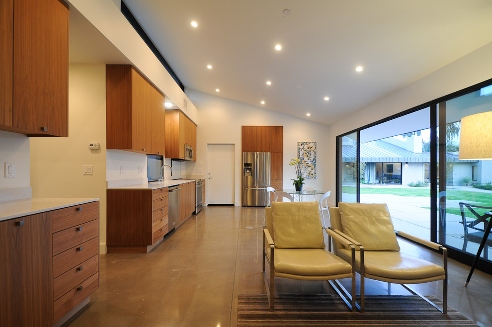 На фото: кухня в стиле модернизм с плоскими фасадами, фасадами цвета дерева среднего тона, техникой из нержавеющей стали, бетонным полом и серым полом с