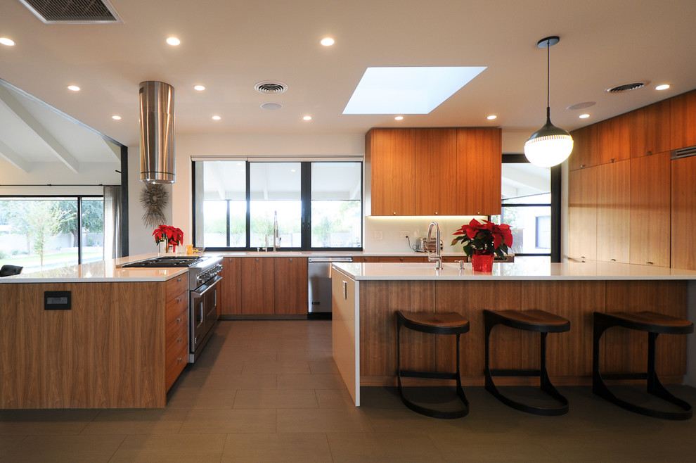 Imagen de cocina moderna con armarios con paneles lisos, puertas de armario de madera oscura, electrodomésticos de acero inoxidable y suelo gris