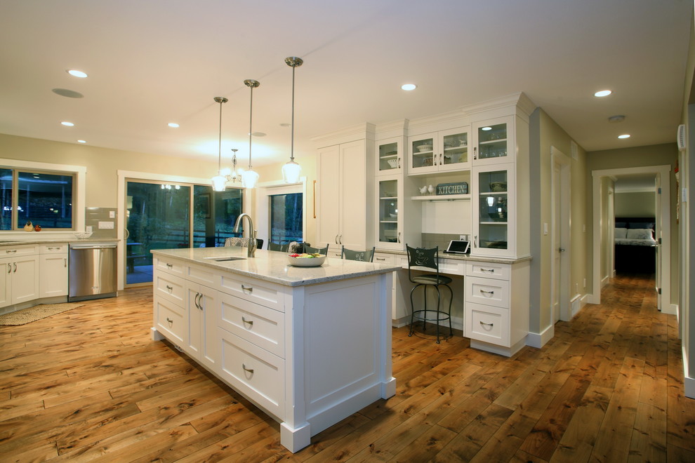 Design ideas for a medium sized traditional u-shaped kitchen in Vancouver with a submerged sink, shaker cabinets, white cabinets, granite worktops, white splashback, ceramic splashback, stainless steel appliances, medium hardwood flooring and an island.