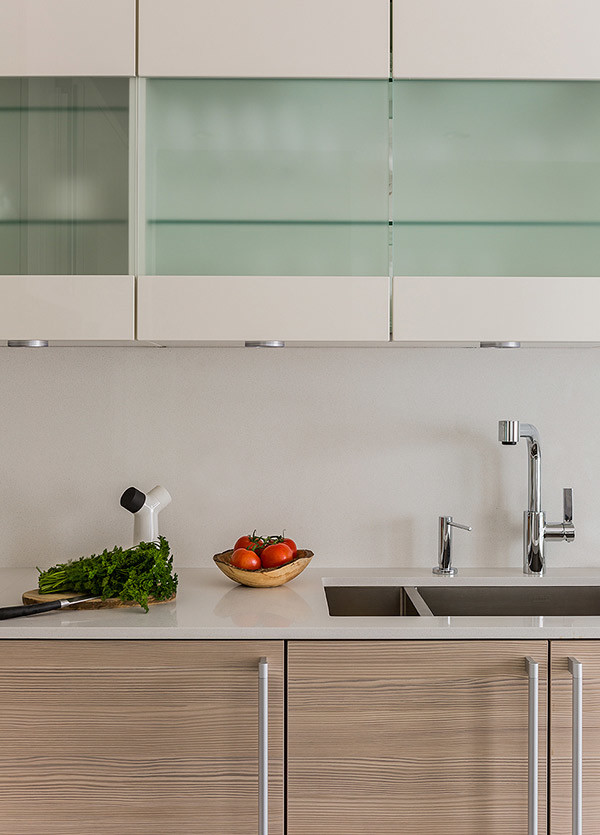 На фото: угловая кухня в современном стиле с серым фартуком, фартуком из стеклянной плитки и полом из керамогранита с