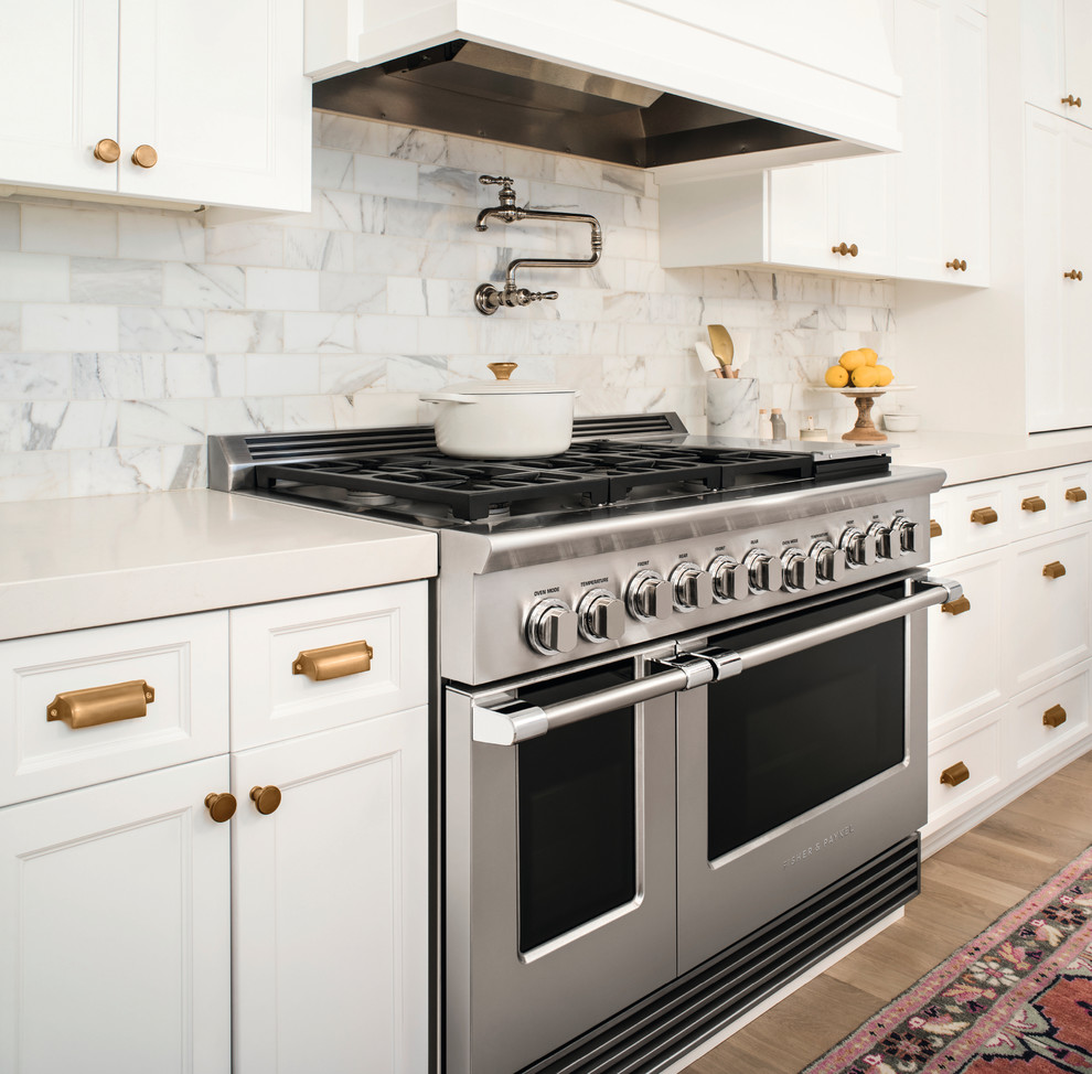 ポートランドにあるシャビーシック調のおしゃれなキッチン (白いキャビネット、シルバーの調理設備) の写真