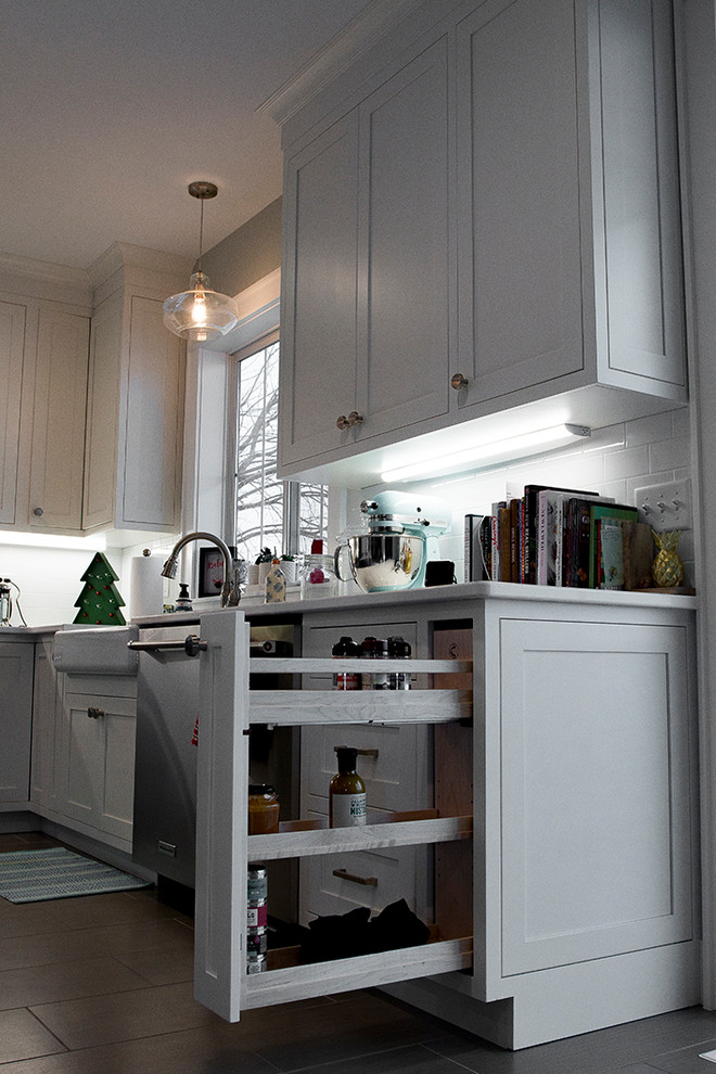 Exempel på ett stort modernt kök, med en rustik diskho, skåp i shakerstil, vita skåp, bänkskiva i kvarts, vitt stänkskydd, stänkskydd i keramik, rostfria vitvaror, klinkergolv i keramik, en köksö och brunt golv