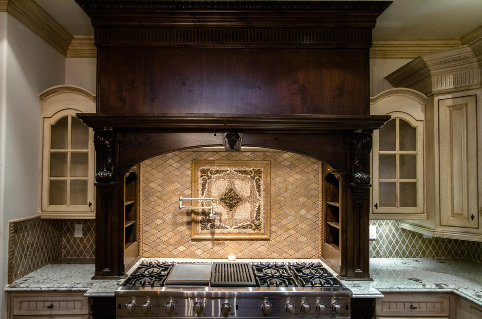Foto på ett stort medelhavsstil kök, med en dubbel diskho, luckor med glaspanel, beige skåp, marmorbänkskiva, beige stänkskydd, stänkskydd i stenkakel, rostfria vitvaror och en köksö
