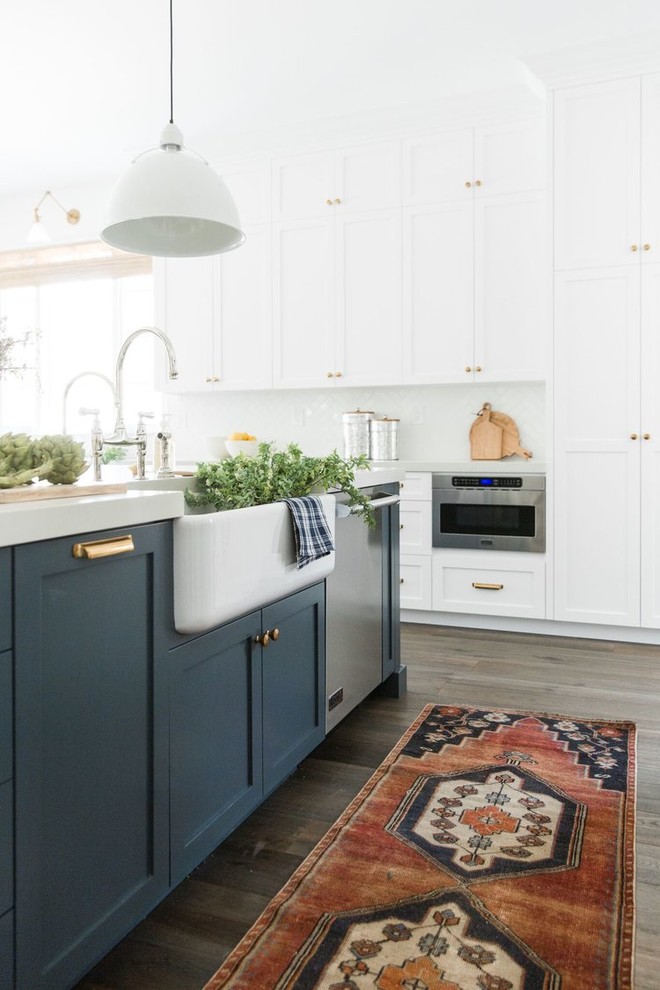 Inspiration for a large transitional galley dark wood floor open concept kitchen remodel in Salt Lake City with a farmhouse sink, shaker cabinets, blue cabinets, white backsplash, subway tile backsplash, stainless steel appliances, an island and white countertops