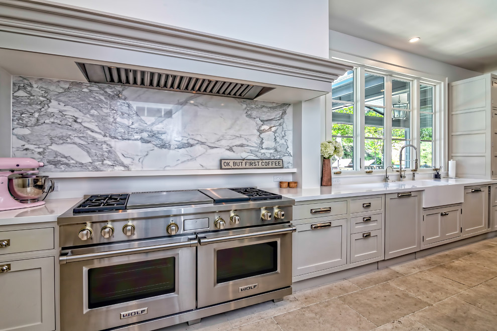 ロサンゼルスにある巨大なおしゃれなキッチン (グレーのキッチンパネル、一体型シンク、シルバーの調理設備) の写真
