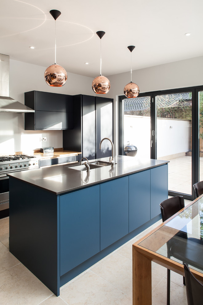 Foto di un cucina con isola centrale minimal con lavello sottopiano, ante lisce, ante nere e elettrodomestici in acciaio inossidabile