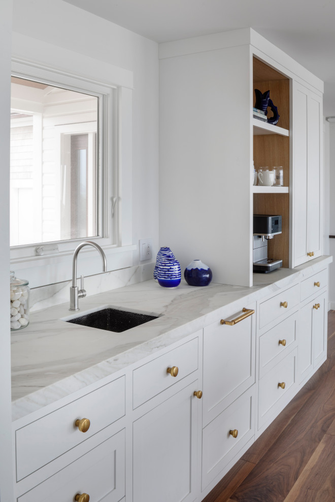 Photo of a large nautical kitchen/diner in Providence with white cabinets, marble worktops and an island.