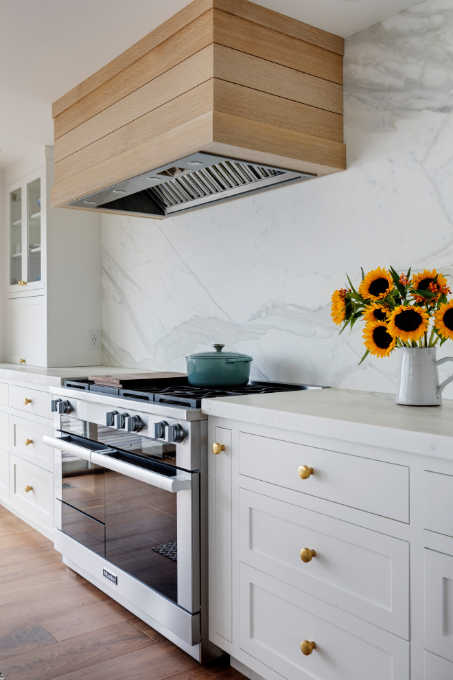 Inspiration for a large coastal eat-in kitchen remodel in Providence with white cabinets, marble countertops and an island