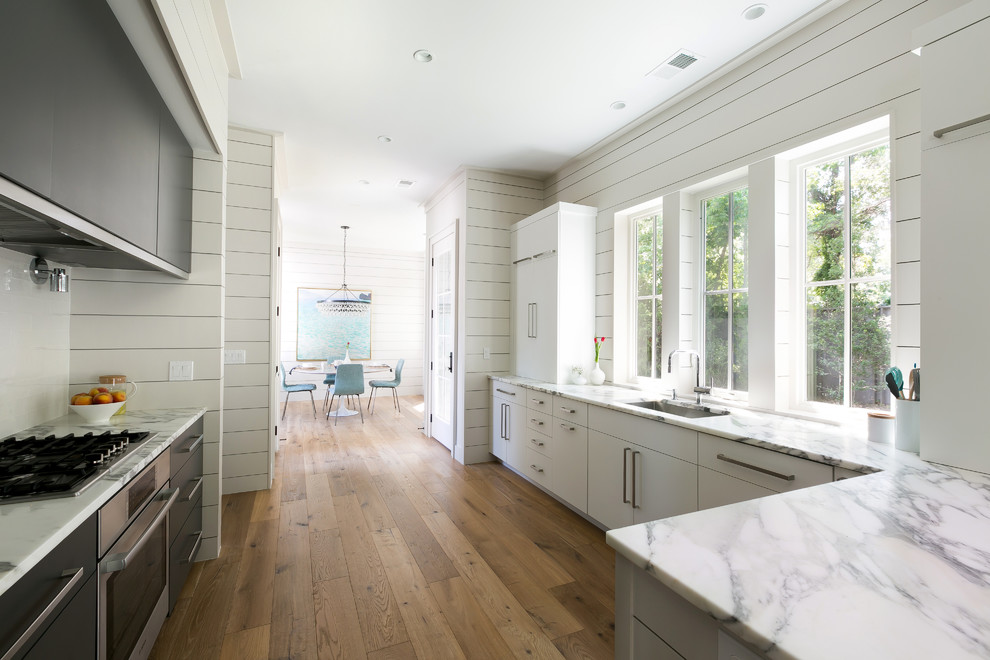 Moderne Küche mit Unterbauwaschbecken, flächenbündigen Schrankfronten, schwarzen Schränken, Küchenrückwand in Weiß und Küchengeräten aus Edelstahl in Charleston