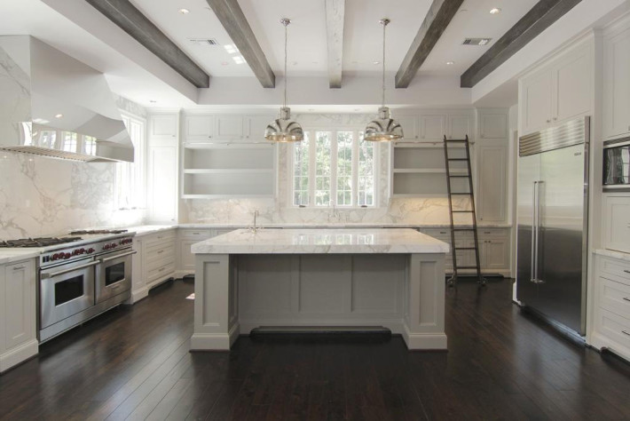 Exempel på ett shabby chic-inspirerat kök, med luckor med infälld panel, vita skåp, marmorbänkskiva, vitt stänkskydd, stänkskydd i marmor, rostfria vitvaror, en köksö och brunt golv