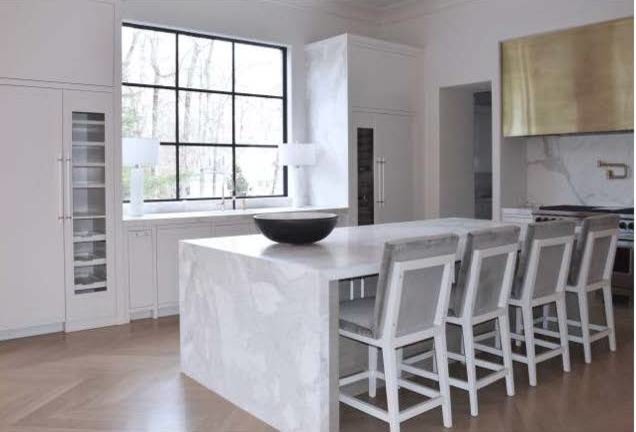 Mid-sized minimalist brown floor open concept kitchen photo in Atlanta with flat-panel cabinets, white cabinets, marble countertops, marble backsplash, stainless steel appliances, an island, white backsplash and an undermount sink