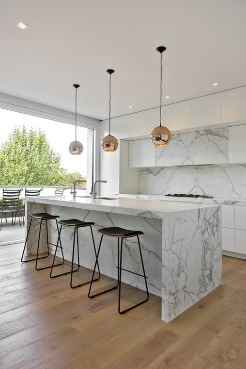 Ispirazione per un grande cucina con isola centrale moderno con lavello sottopiano, top in marmo, paraspruzzi bianco e paraspruzzi in lastra di pietra