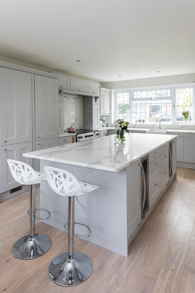 Medium sized contemporary l-shaped kitchen in Other with raised-panel cabinets, grey cabinets, marble worktops, white splashback, marble splashback, an island and beige floors.