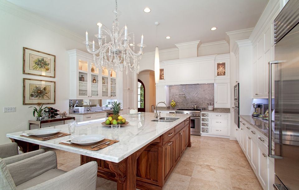 Large eclectic l-shaped travertine floor and beige floor open concept kitchen photo in Miami with an undermount sink, shaker cabinets, white cabinets, quartz countertops, gray backsplash, stone slab backsplash, stainless steel appliances and an island