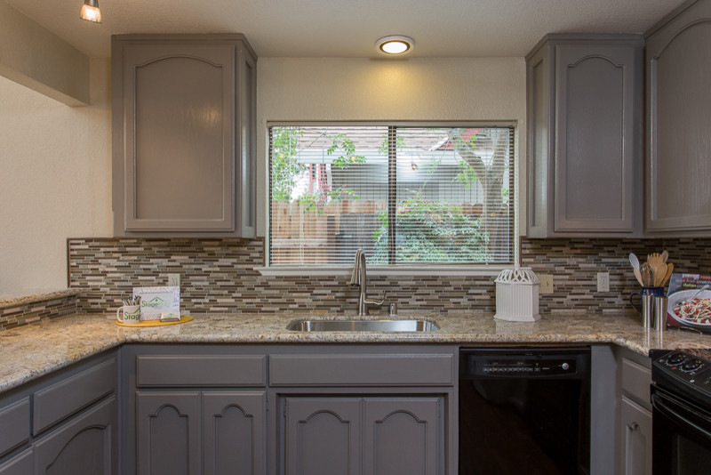 Small elegant u-shaped eat-in kitchen photo in Sacramento with an undermount sink, recessed-panel cabinets, gray cabinets, granite countertops, gray backsplash, matchstick tile backsplash, black appliances and no island