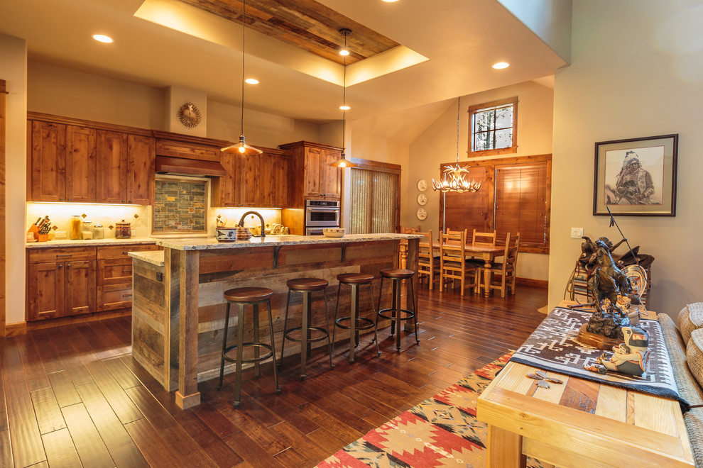Zweizeilige Urige Küche mit Schrankfronten im Shaker-Stil, hellbraunen Holzschränken, Küchengeräten aus Edelstahl, dunklem Holzboden, Kücheninsel und braunem Boden in Sonstige