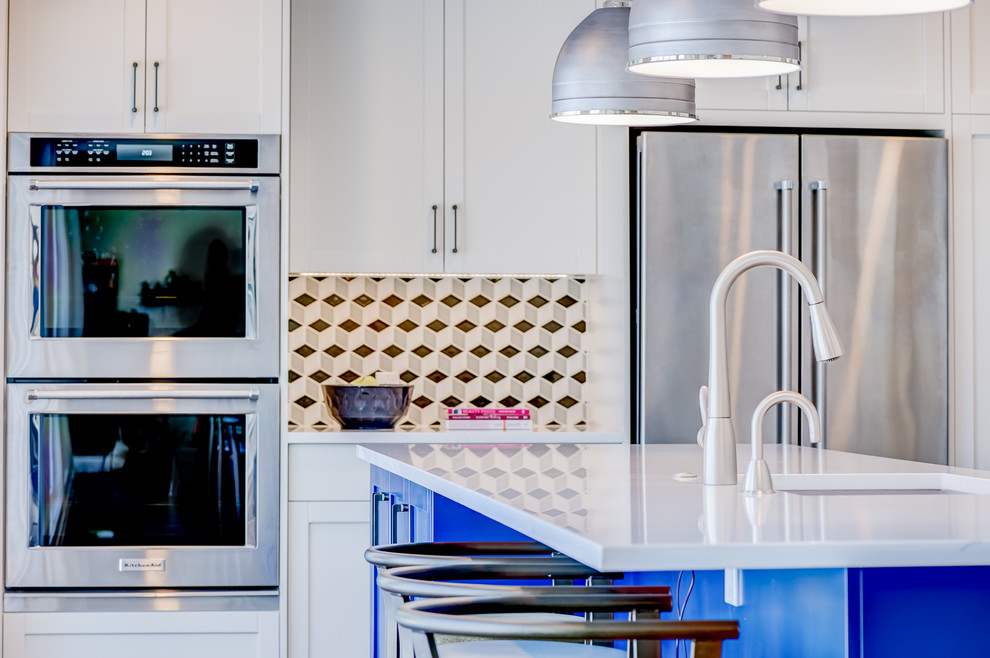 Modern inredning av ett stort kök, med en undermonterad diskho, skåp i shakerstil, blå skåp, bänkskiva i kvarts, flerfärgad stänkskydd, stänkskydd i mosaik, rostfria vitvaror, vinylgolv, en köksö och brunt golv