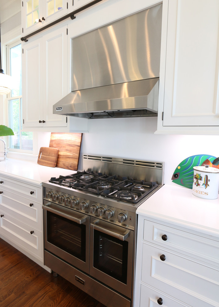 Idéer för att renovera ett stort vintage kök, med en undermonterad diskho, luckor med infälld panel, vita skåp, marmorbänkskiva, vitt stänkskydd, rostfria vitvaror, mörkt trägolv, en köksö och brunt golv