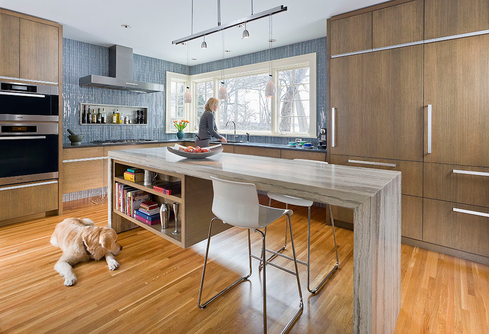На фото: кухня в современном стиле с синим фартуком и мойкой у окна с