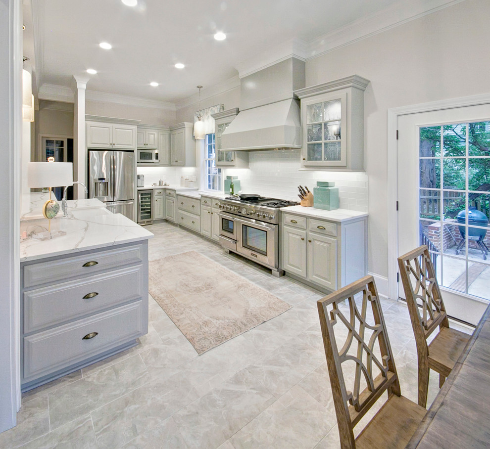 Large transitional galley eat-in kitchen photo in Other with a farmhouse sink, raised-panel cabinets, gray cabinets, quartzite countertops, white backsplash, glass tile backsplash, stainless steel appliances and no island