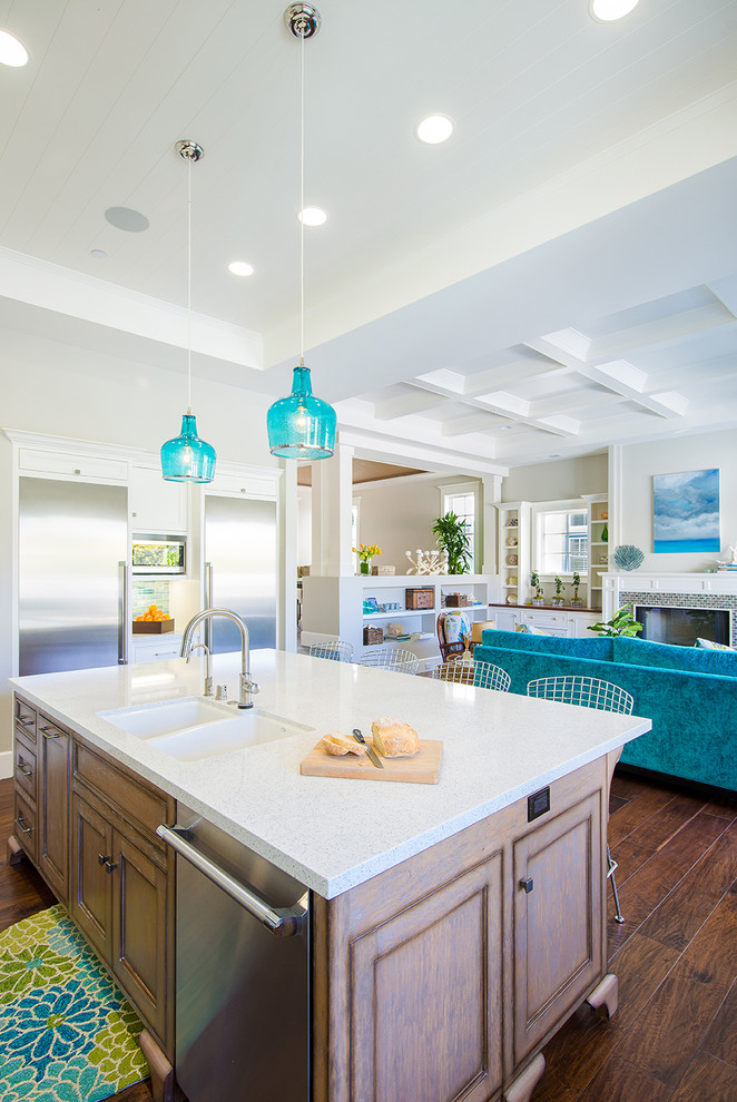 Large beach style l-shaped open plan kitchen in Los Angeles with recessed-panel cabinets, white cabinets, engineered stone countertops, multi-coloured splashback, mosaic tiled splashback, stainless steel appliances, an island, a submerged sink, dark hardwood flooring, brown floors and white worktops.