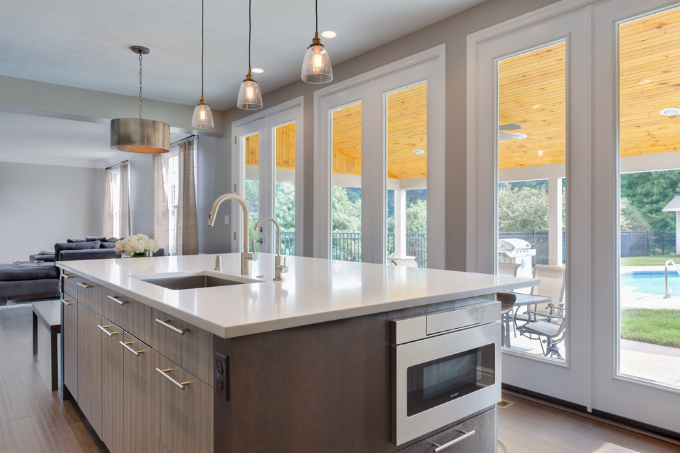 Mid-sized transitional l-shaped dark wood floor and brown floor eat-in kitchen photo in Other with an undermount sink, flat-panel cabinets, brown cabinets, laminate countertops, gray backsplash, glass sheet backsplash, paneled appliances and an island