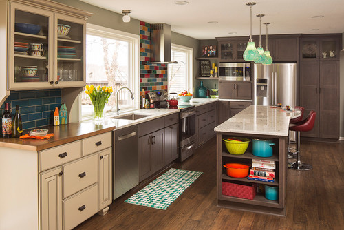 Modern kitchen showcasing cabinet color trends with two-tone design — cream upper cabinets, dark gray lower cabinets, and vibrant backsplash tiles.