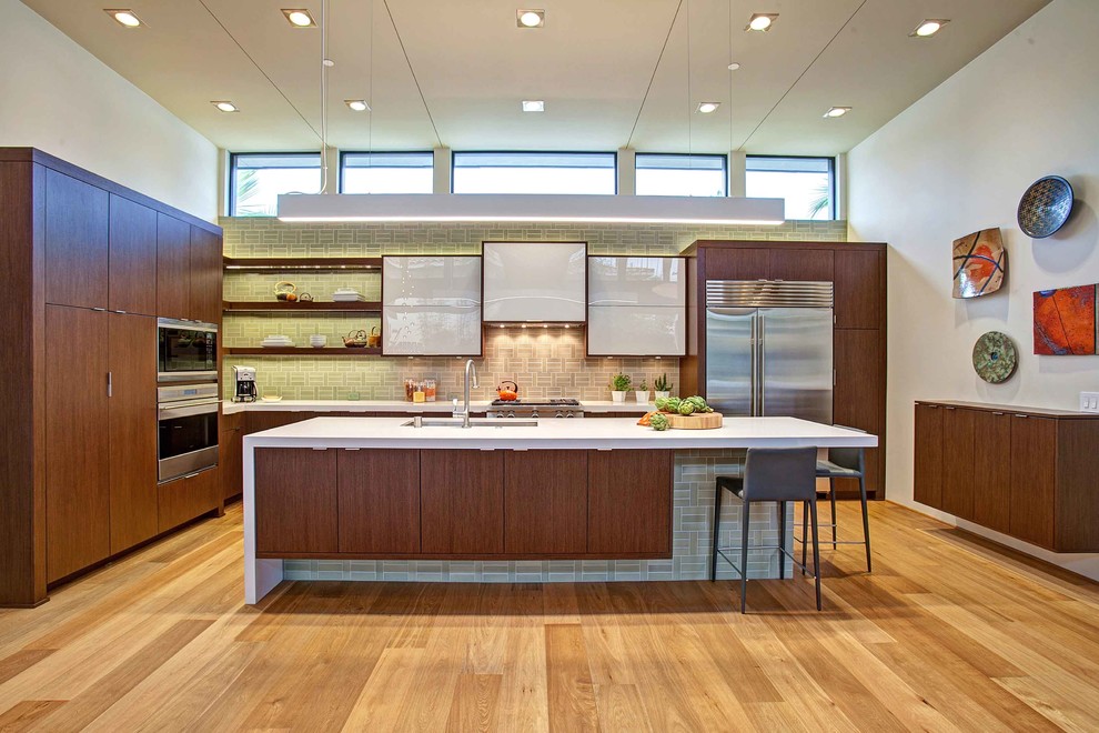 Inspiration for a contemporary u-shaped kitchen remodel in San Diego with an undermount sink, flat-panel cabinets, dark wood cabinets, green backsplash and stainless steel appliances