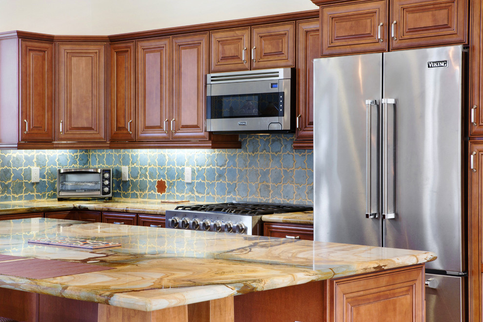Exempel på ett mellanstort medelhavsstil kök, med en undermonterad diskho, luckor med upphöjd panel, skåp i mellenmörkt trä, bänkskiva i onyx, blått stänkskydd, rostfria vitvaror, klinkergolv i keramik och en köksö