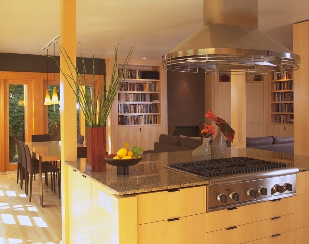 Свежая идея для дизайна: кухня-гостиная в современном стиле с плоскими фасадами, светлыми деревянными фасадами и техникой из нержавеющей стали - отличное фото интерьера
