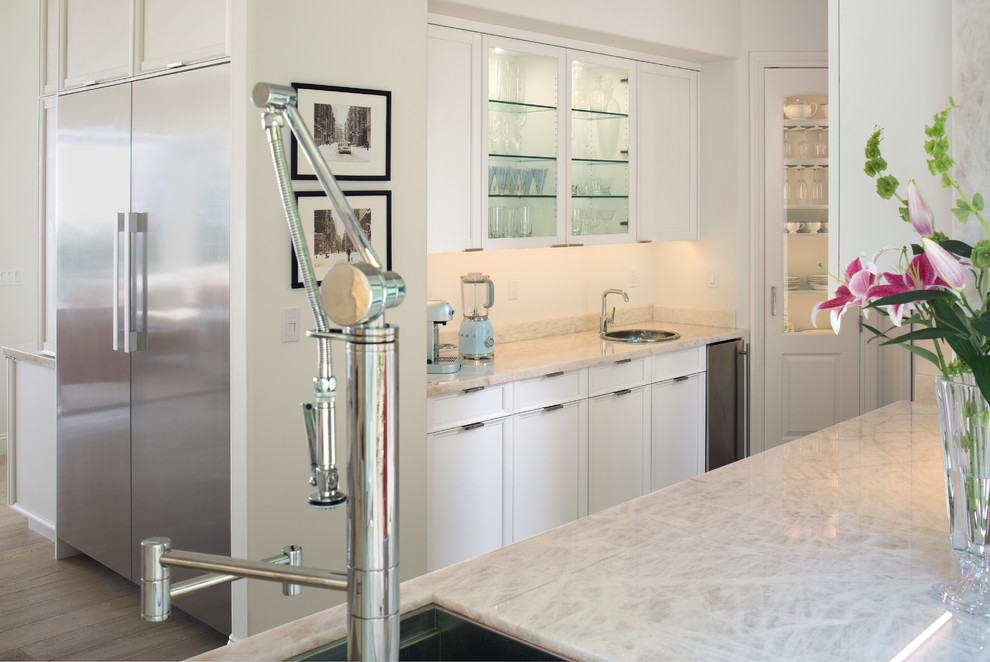 Exempel på ett stort klassiskt vit vitt kök, med en integrerad diskho, luckor med infälld panel, vita skåp, bänkskiva i onyx, vitt stänkskydd, rostfria vitvaror, laminatgolv, grått golv och flera köksöar