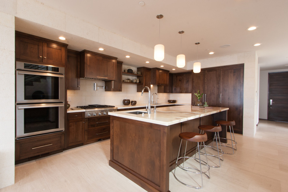 Imagen de cocina minimalista abierta con armarios con paneles empotrados, puertas de armario de madera en tonos medios y una isla