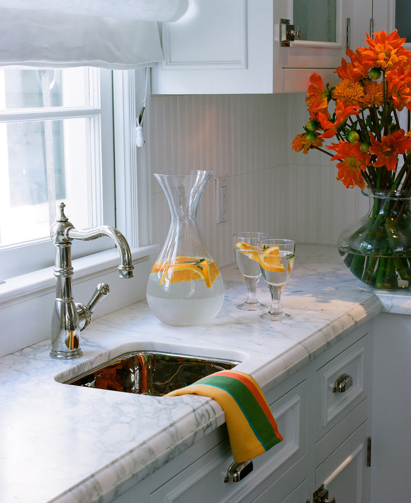 Foto på ett mellanstort vintage kök med öppen planlösning, med en rustik diskho, luckor med glaspanel, vita skåp, marmorbänkskiva, vitt stänkskydd, rostfria vitvaror, mellanmörkt trägolv och en köksö