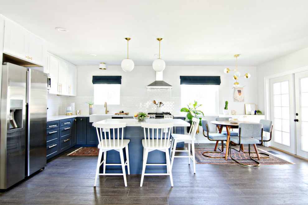 Inspiration for a mid-sized mid-century modern l-shaped dark wood floor eat-in kitchen remodel in San Francisco with a farmhouse sink, shaker cabinets, blue cabinets, marble countertops, white backsplash, ceramic backsplash, stainless steel appliances and an island